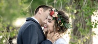 a bride and groom kissing in front of a tree