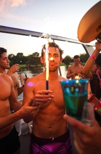 a man holding a sparkler on a boat