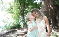two children hugging in front of a tree