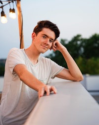 a young man leaning against a railing